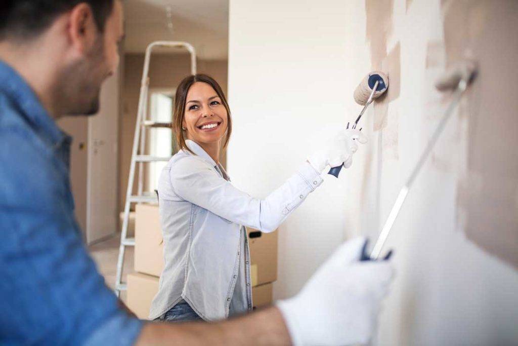 Beautiful Woman Painting Wall With Roller.